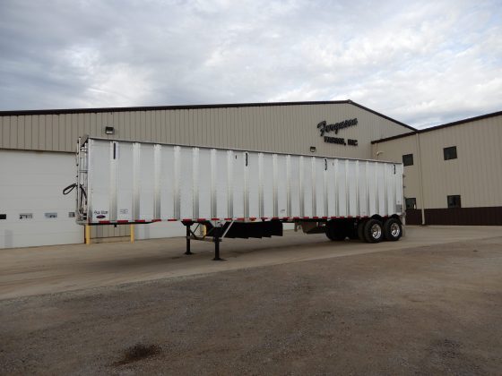 White belt trailer in front of a shop